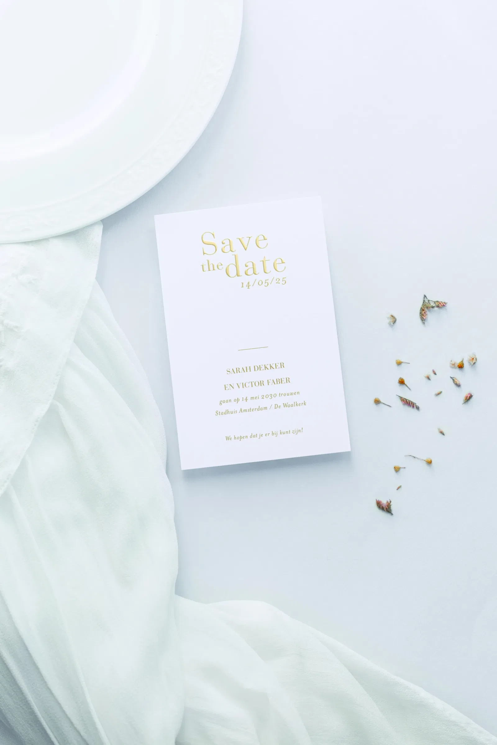 Witte save-the-date-kaart voor een bruiloft met confetti. De tekst op de kaart zijn goude letters