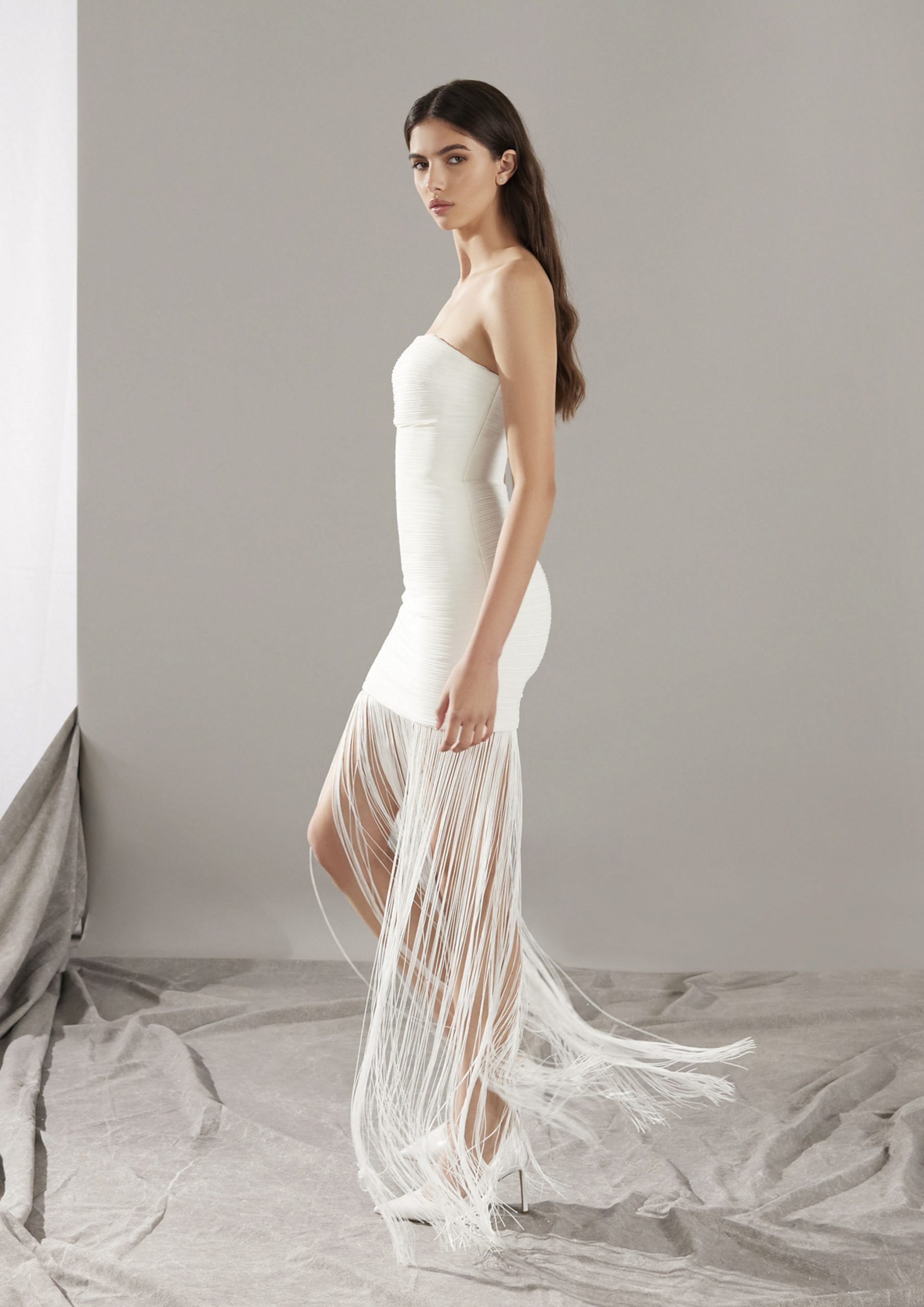 Bruid in korte off-the-shoulder trouwjurk met fransjes.