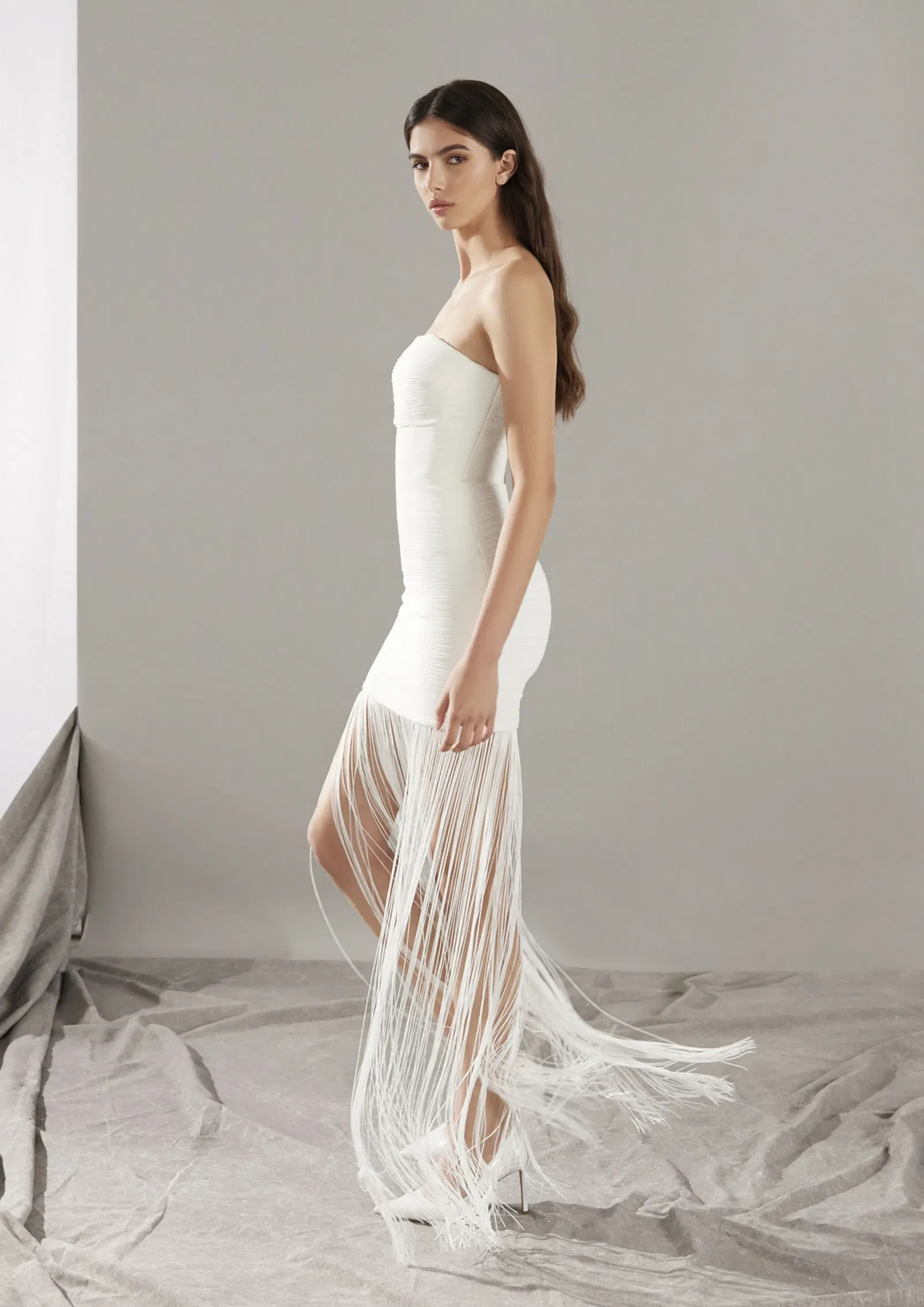 Bruid in korte off-the-shoulder trouwjurk met fransjes.