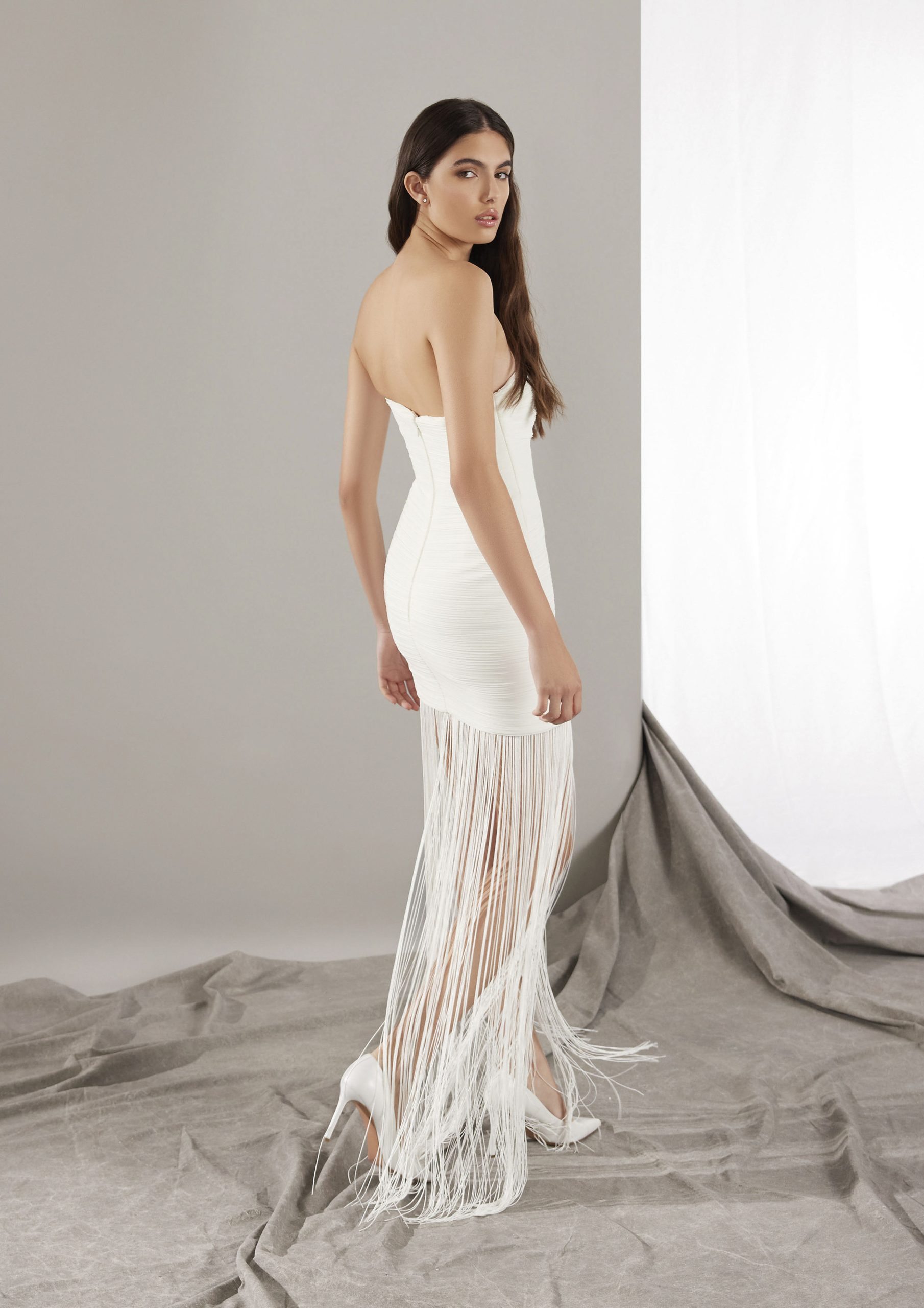 Bruid in korte off-the-shoulder trouwjurk met fransjes.