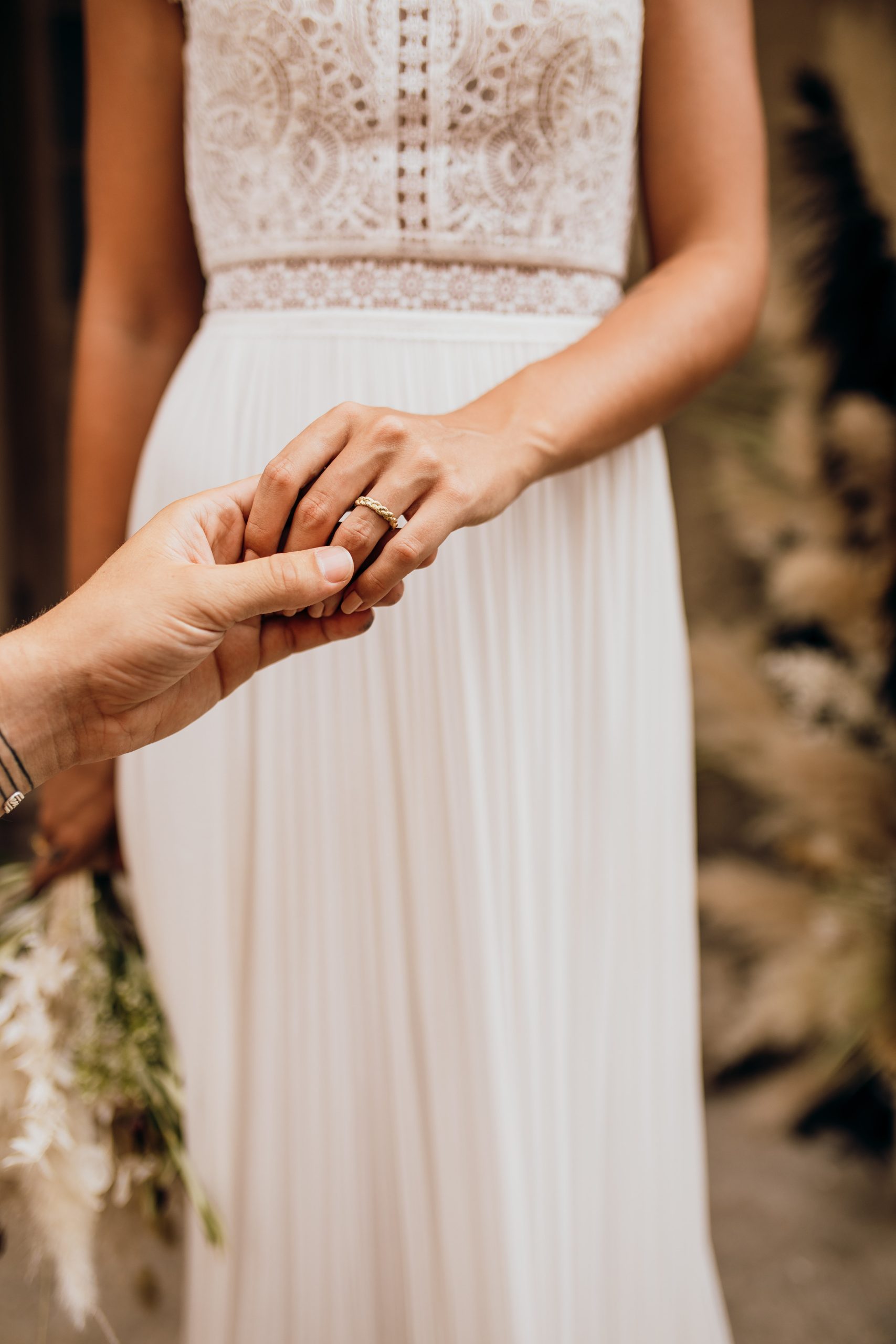 Man die hand vrouw vasthoudt, vrouw heeft gouden trouwring om.