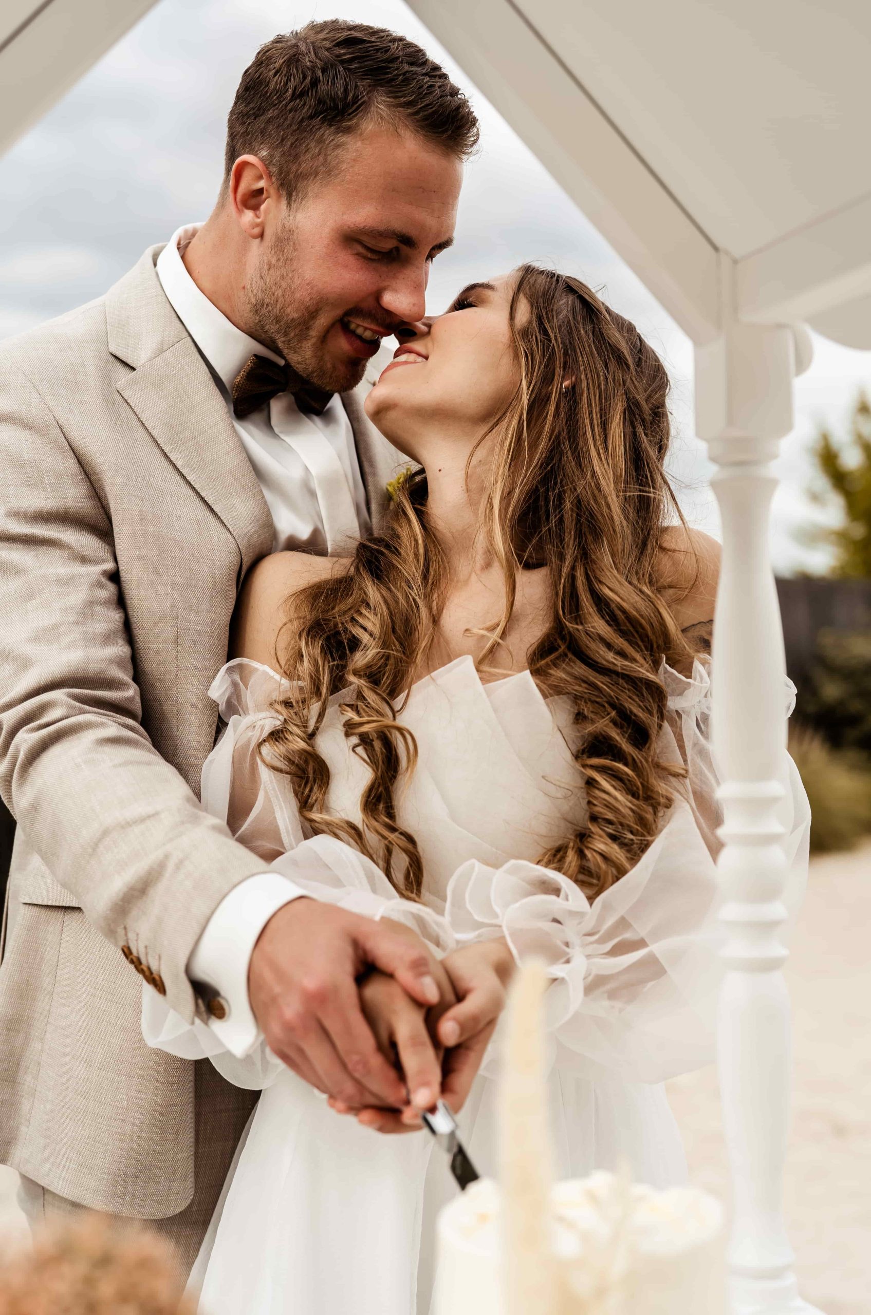 Bruidspaar die hun bruidstaart aansnijdt.