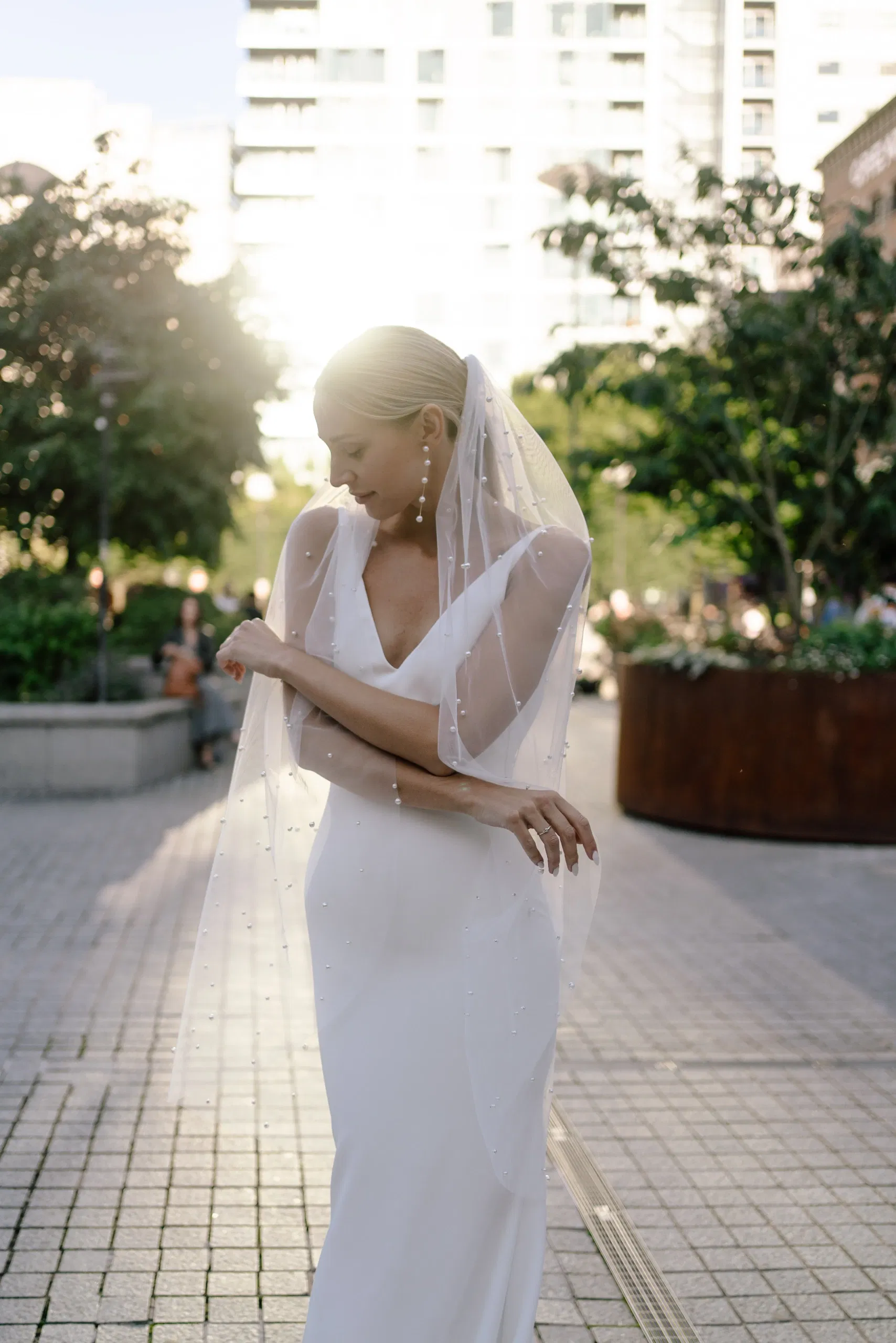 Een bruid met haar bruidsjurk in de zon