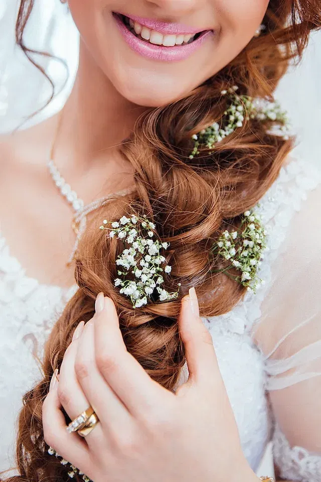 Een bruid met haar bruidskapsel met bloemen erin