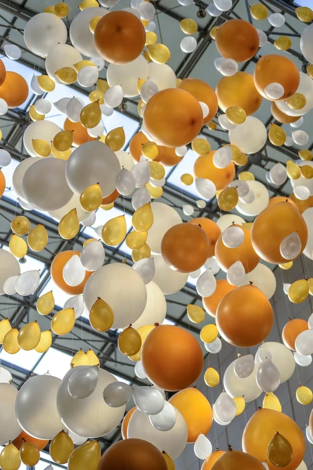 Gouden en zilveren ballonen aan het plafond.