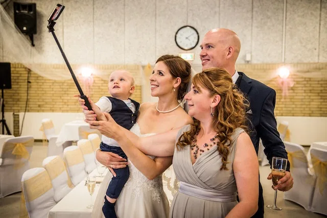 Gezin op bruiloft met klein kindje maakt selfie