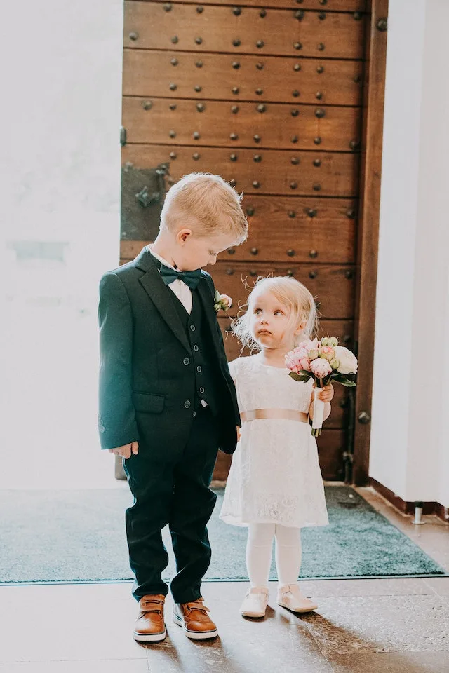 twee kindjes in nette kleding voor bruiloft.