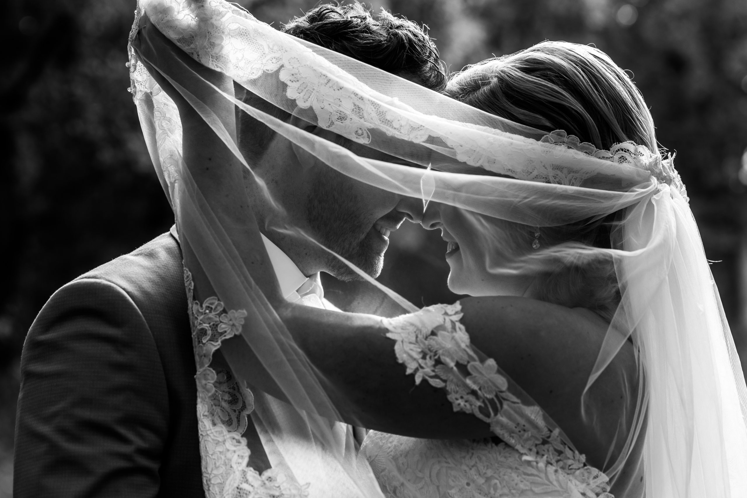 Trouwfoto bruidspaar onder sluier