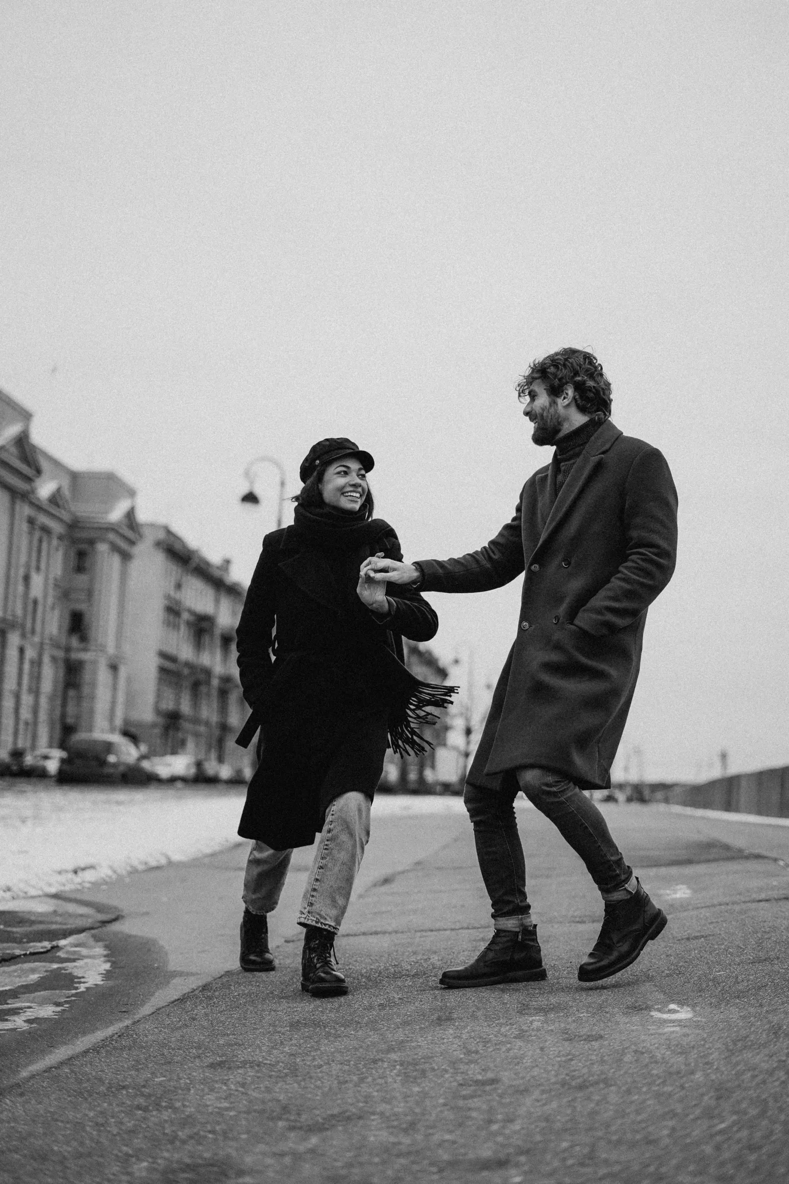 man en vrouw lopen dik gekleed hand in hand over de boulevard