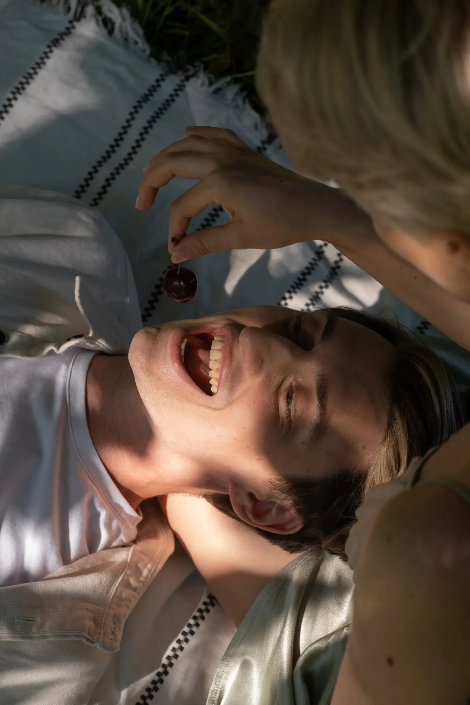 vrouw voert man een kers op een kleedje