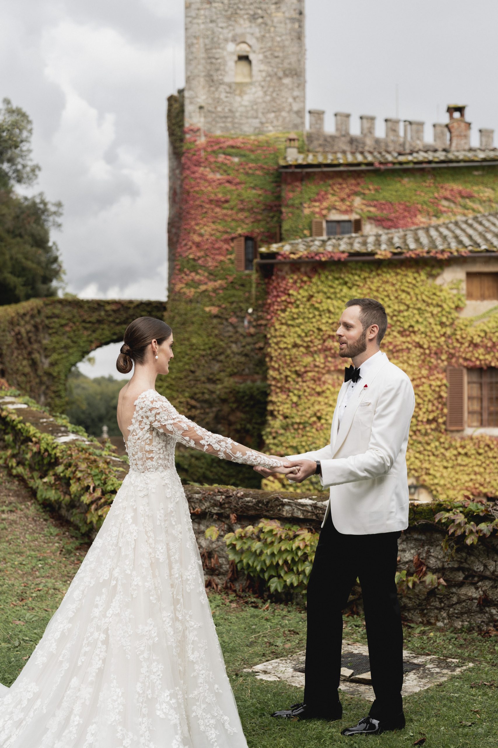 Trouwfoto. Bruidsmode CEO Justin Alexander en vrouw Kelsey Turchy houden elkaars hand vast in trouwkleding.