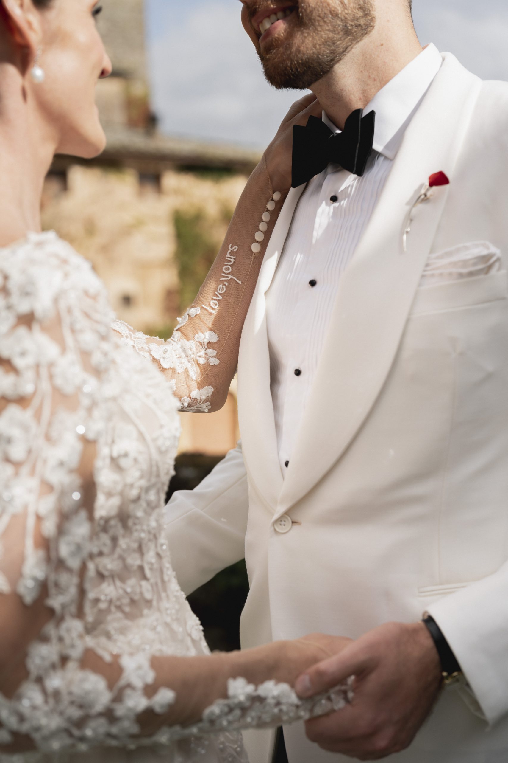 Bruidsmode CEO Justin Alexander en vrouw Kelsey Turchy details trouwkleding. Jurk met bloemen en wit pak.