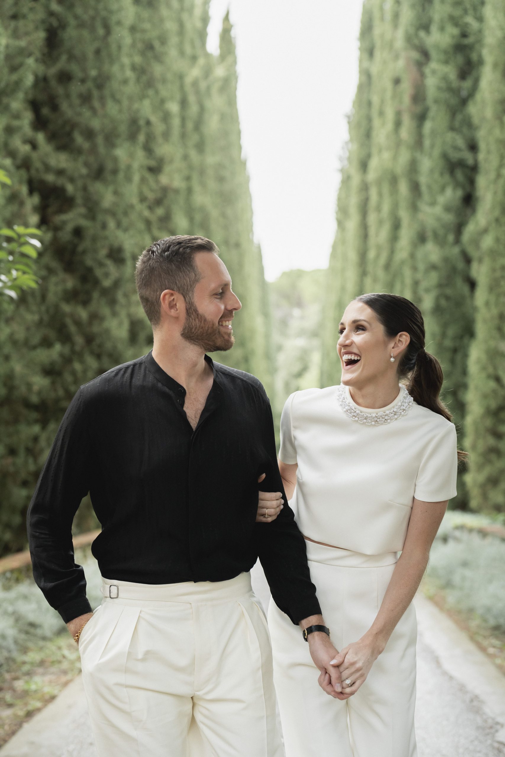 Bruidsmode CEO Justin Alexander en vrouw Kelsey Turchy houden elkaars hand vast.