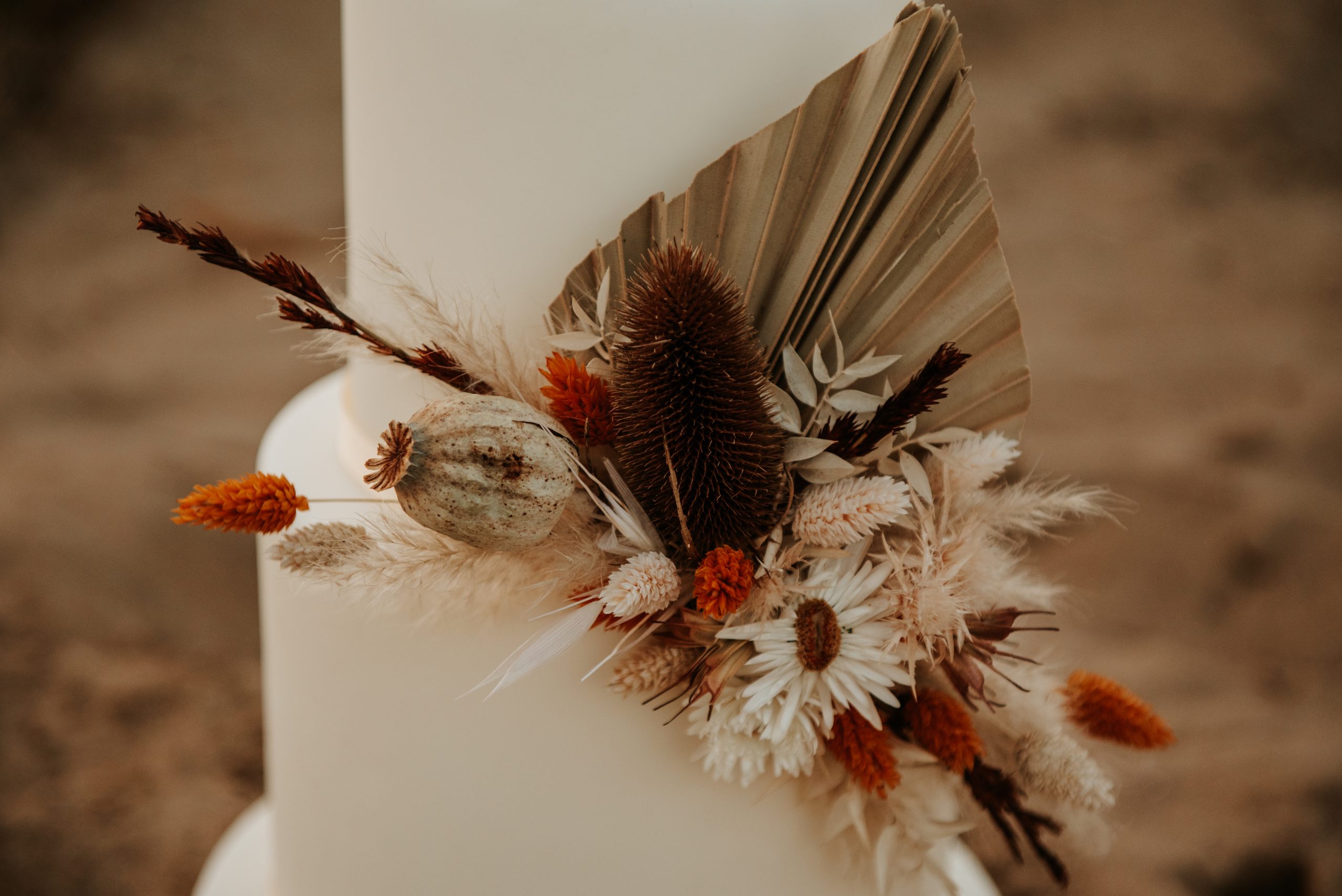 Witte bruidstaart met droogbloemen versiering in de duinen