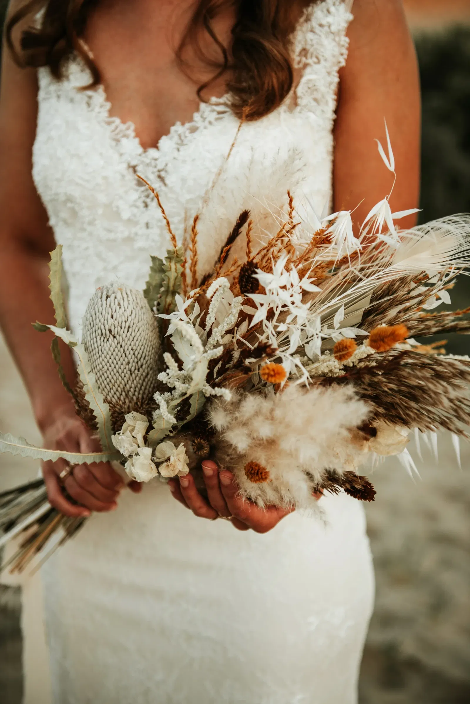 Bruidsbloemen met veren en een witte trouwjurk