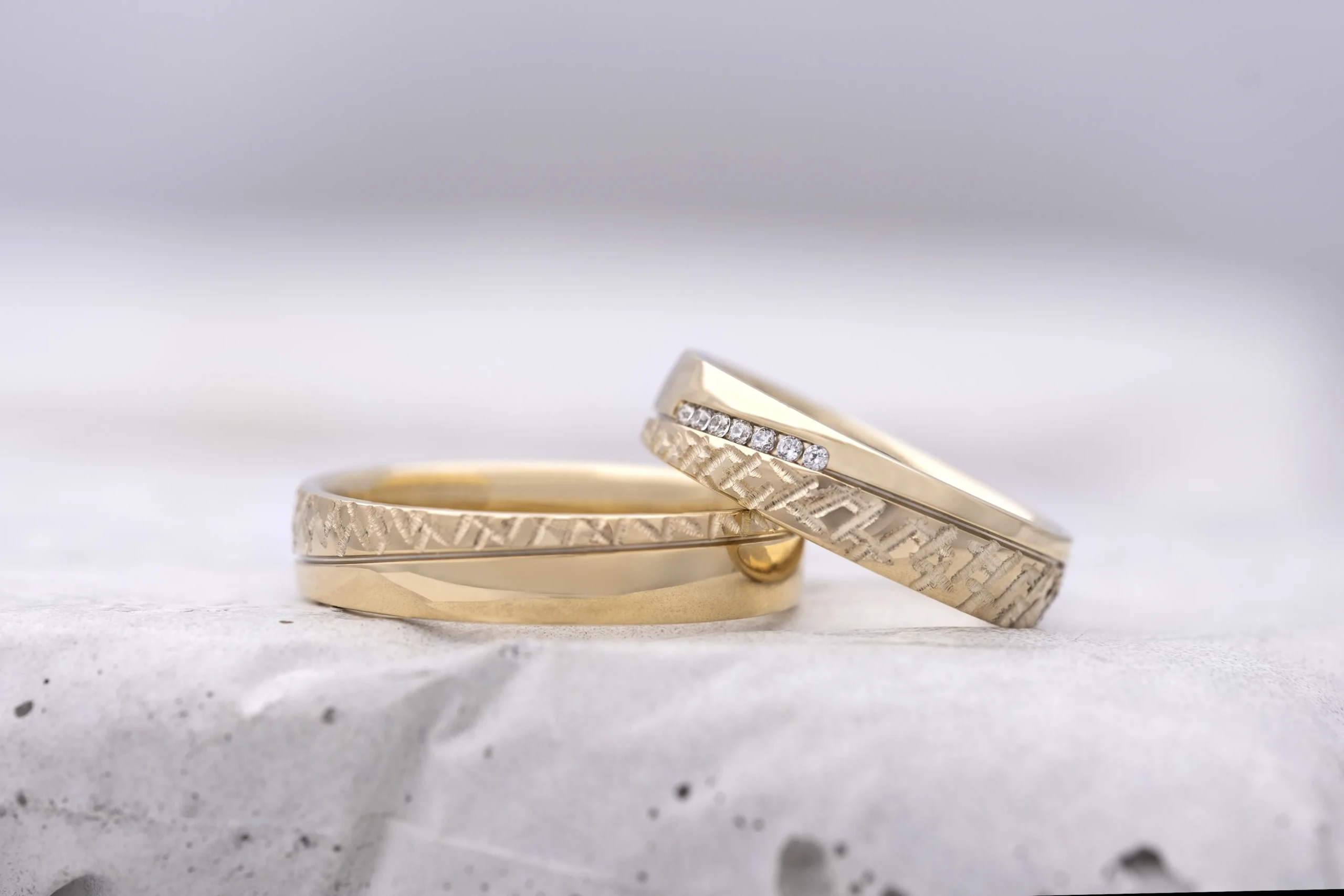 Op de gouden heren trouwring ligt de trouwring voor de vrouw met een rijtje diamanten van Aller Spanninga.