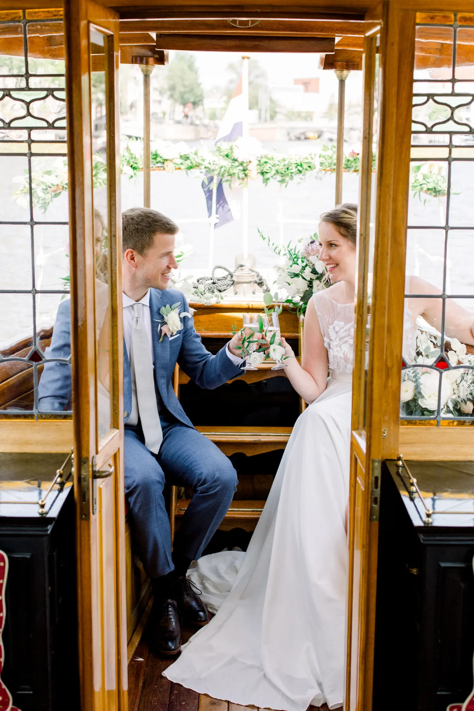 Bruidspaar toost op de Salonboot de Liefde het champagne glas.