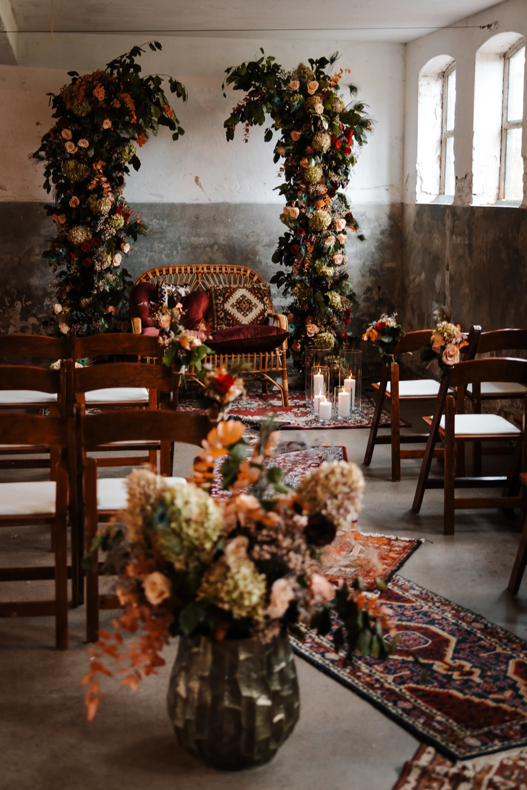 Een kamer ingericht voor de huwelijksceremonie met Oosterse tapijten, bloemen, donker houten stoelen en een rotan bankje met kussen voor het bruidspaar.