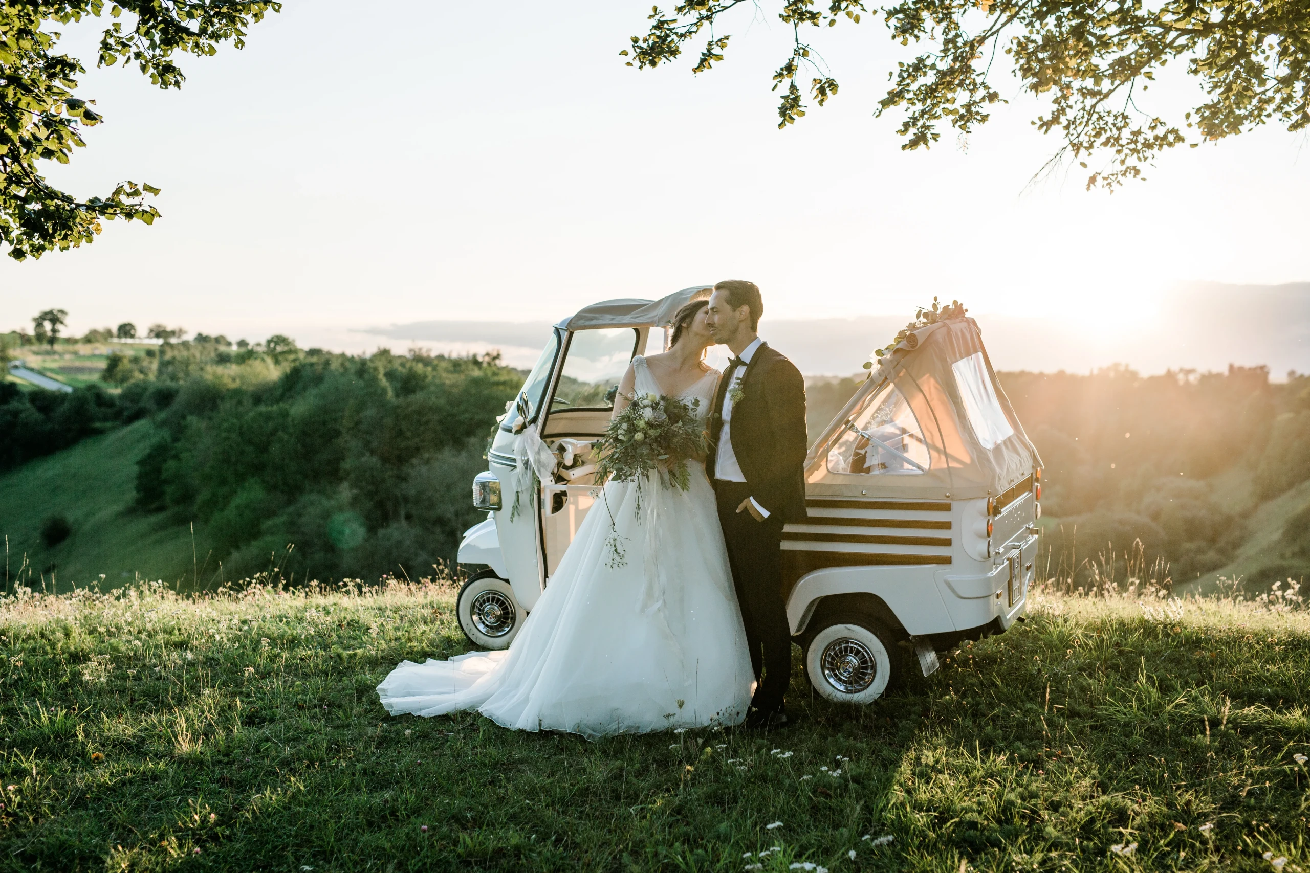 Bruid kust bruidegom bij ondergaande zon op een berg voor een tuktuk cabrio