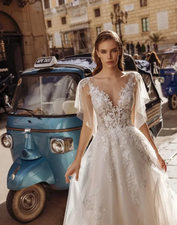 Bruid staat op een Italiaans plein voor een blauwe tuktuk trouwvervoer