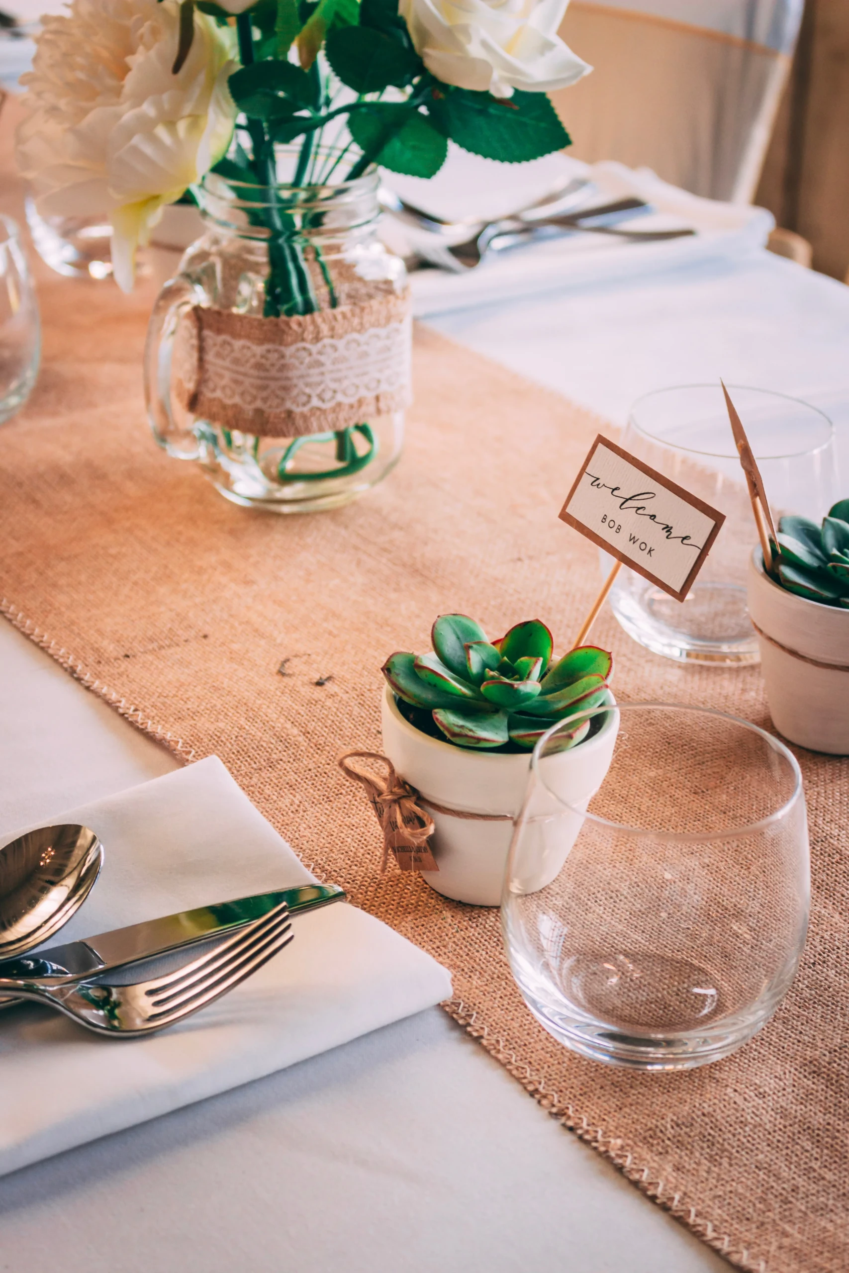 met bloemen gedecoreerde eettafel met zilverwerk