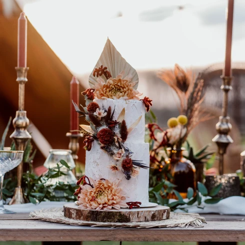 Golden hour shoot met botanische taart met veel bloemen. De tafel is decoratief gevuld,