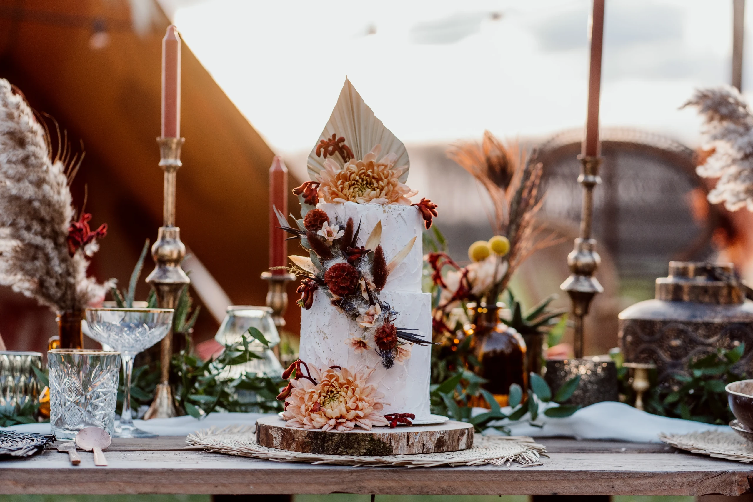 Golden hour shoot met botanische taart met veel bloemen. De tafel is decoratief gevuld,
