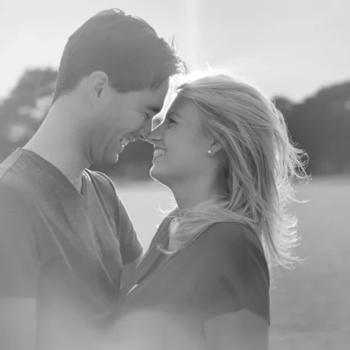 Man en vrouw staan lachend neus aan neus inde Soesterduinen.