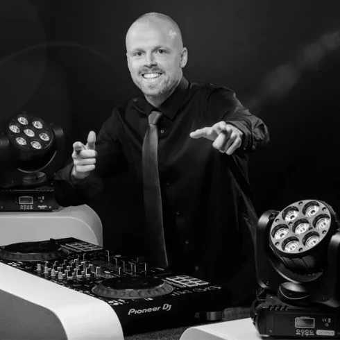 De SKYFLY DJ staat achter een mengtafel.