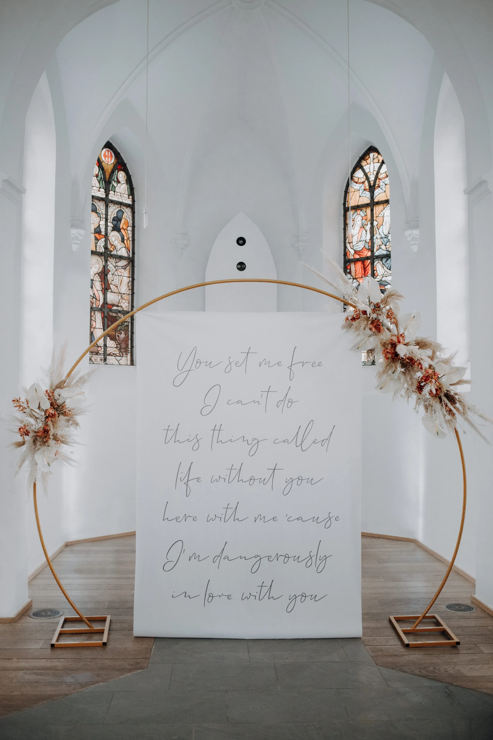 Bloemenboog in kerk met tekst van gedicht erop.