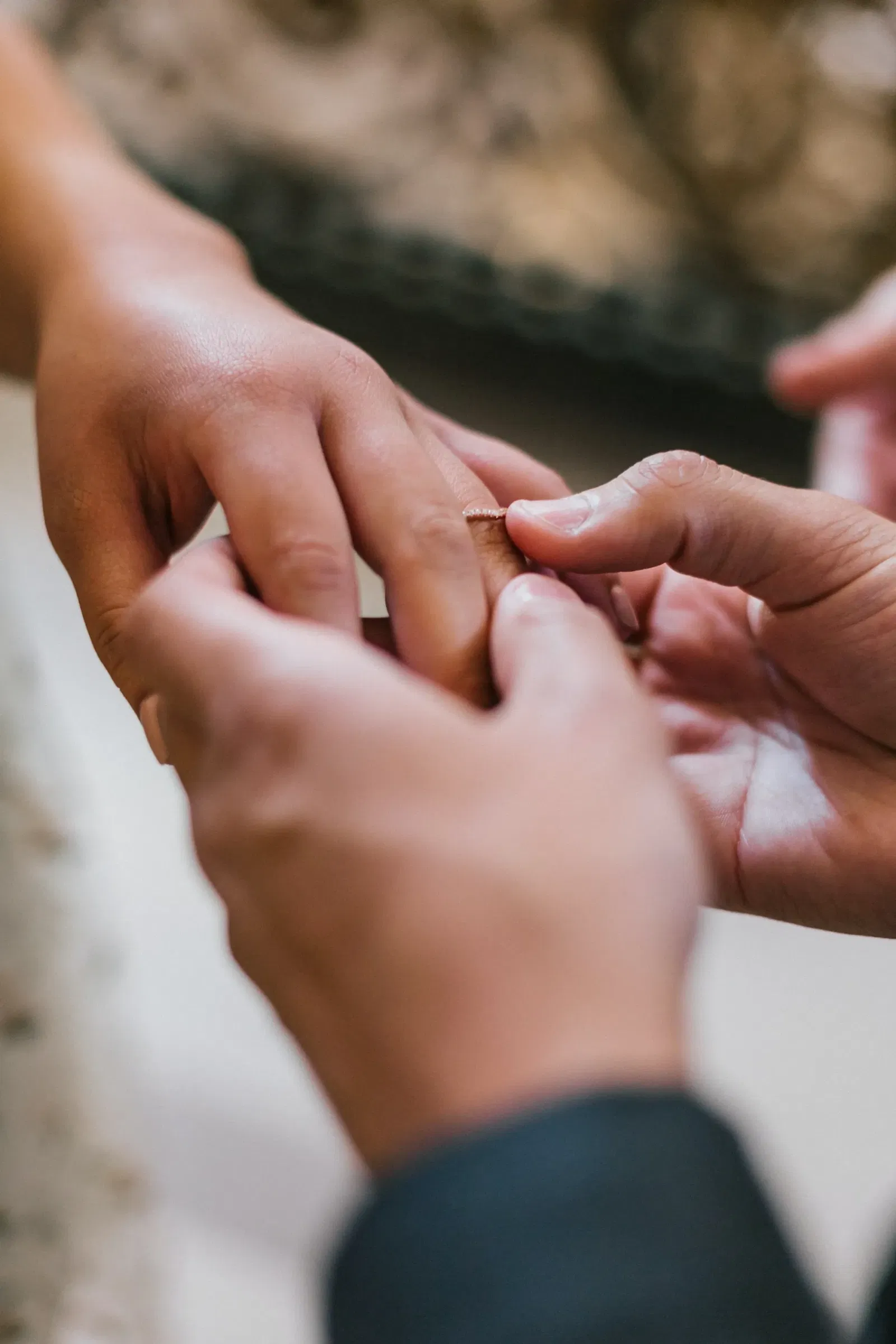 Man doet ring om vinger tijdens ceremonie van bruiloft.