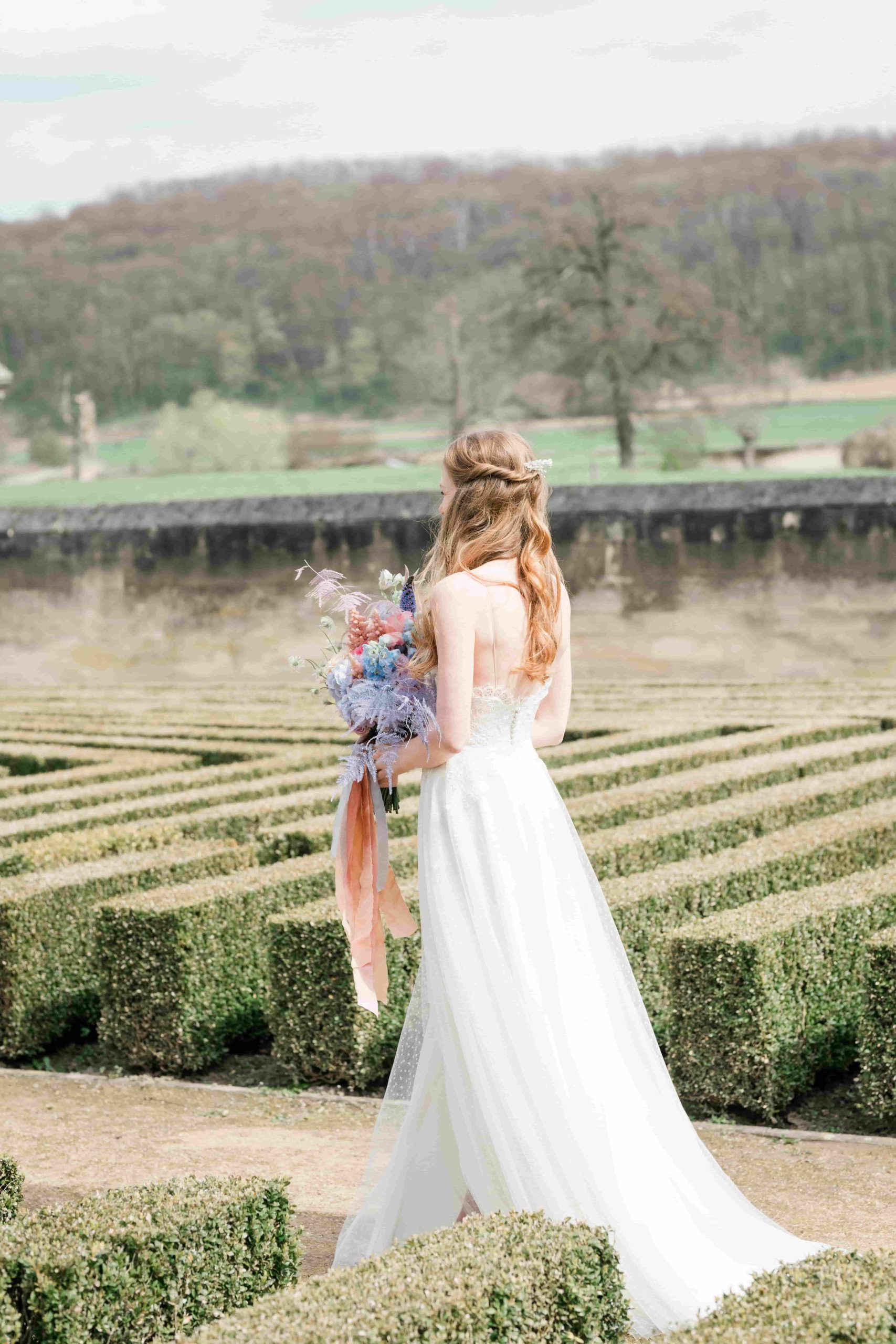 Een bruid met bloemen voor een tuin