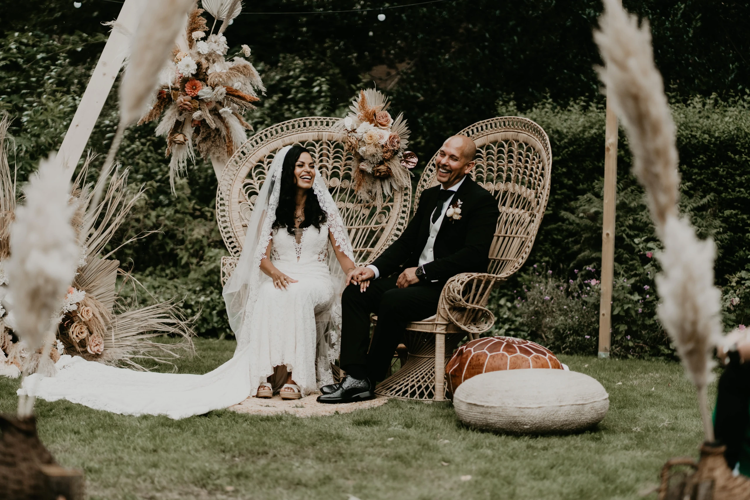 Bruidspaar op festival boho bruiloft zitten op stoelen bij de ceremonie.