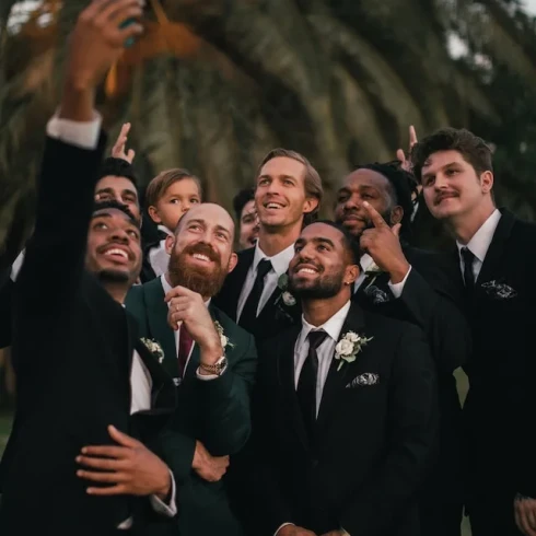 Lachende mannen op een bruiloft die een foto maken