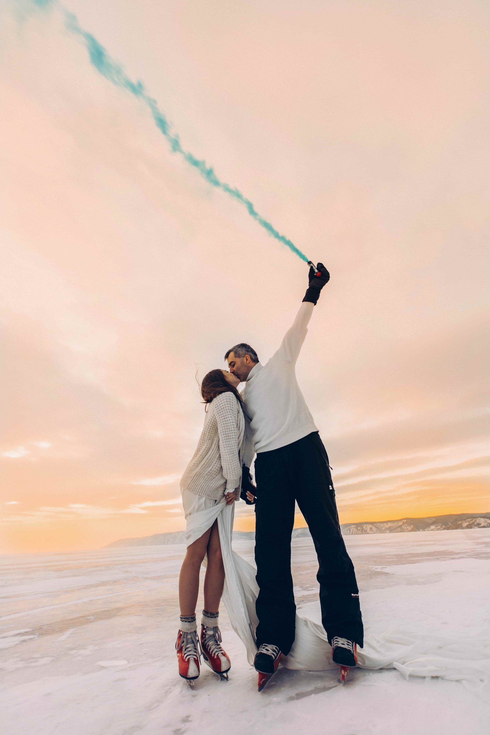 Een koppel met vuurwerk in de sneeuw