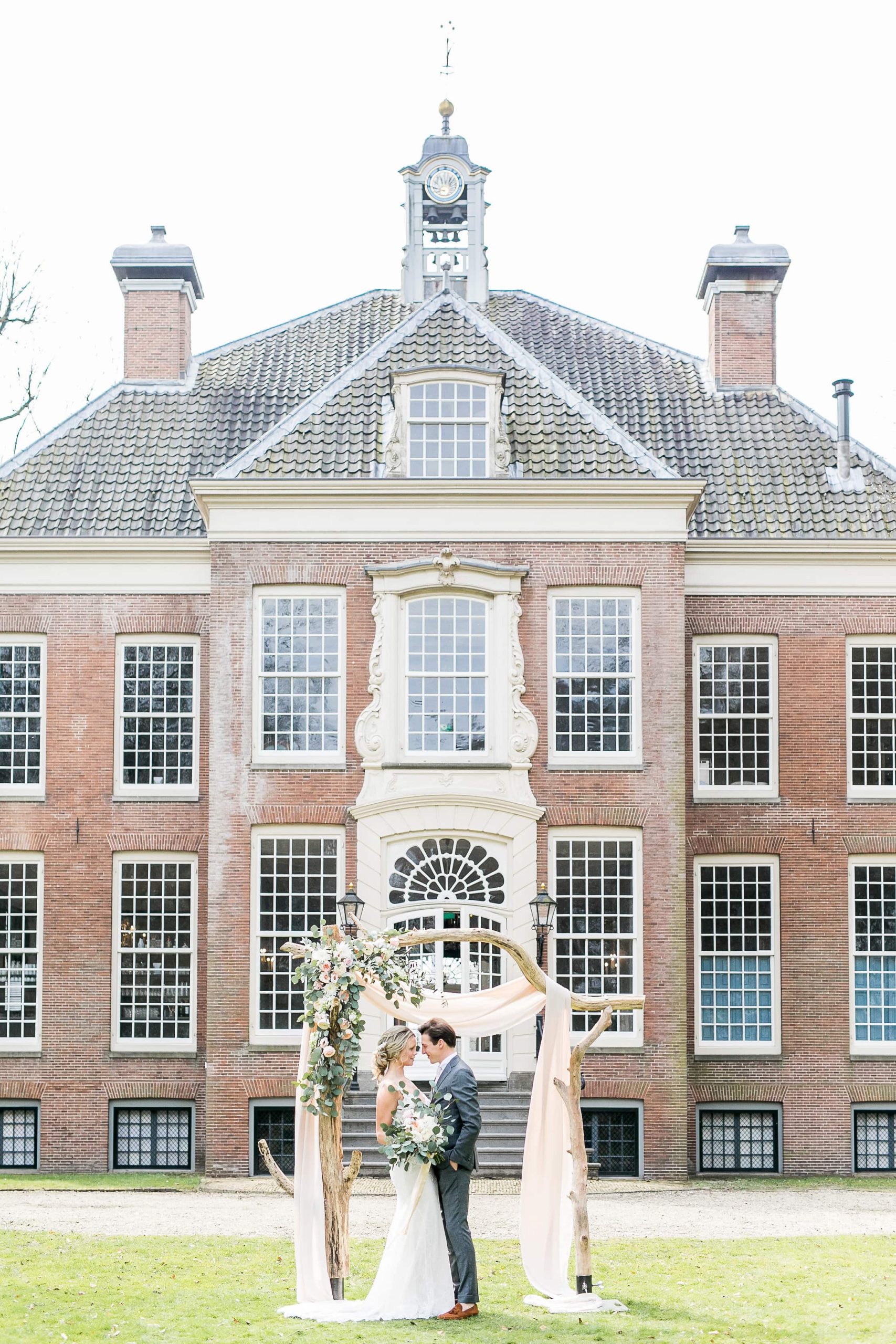 Bruidspaar voor trouwlocatie, groot landhuis.