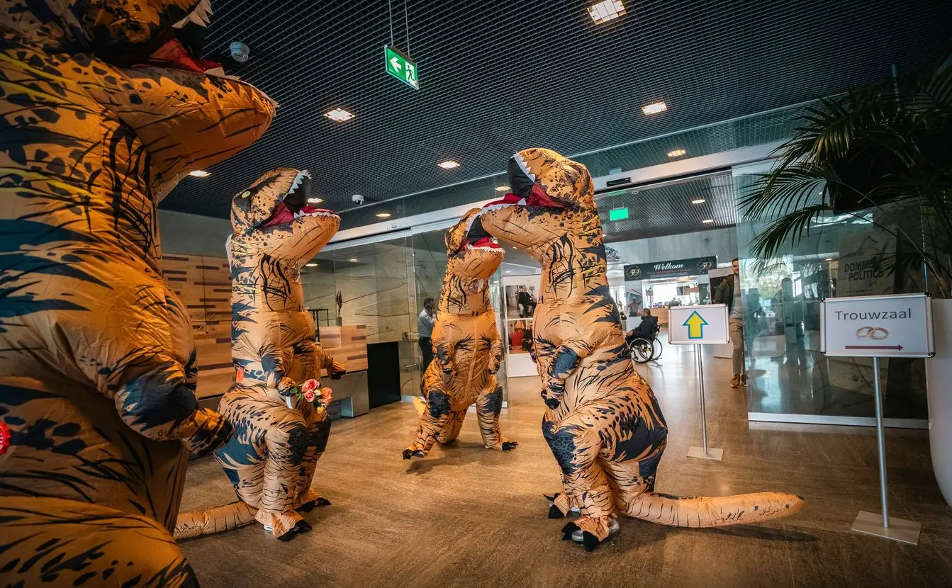 Bijzondere bruiloft met bruidspaar in dinopakken