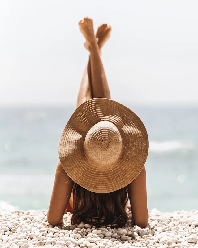 Vrouw op het strand met een hoed op
