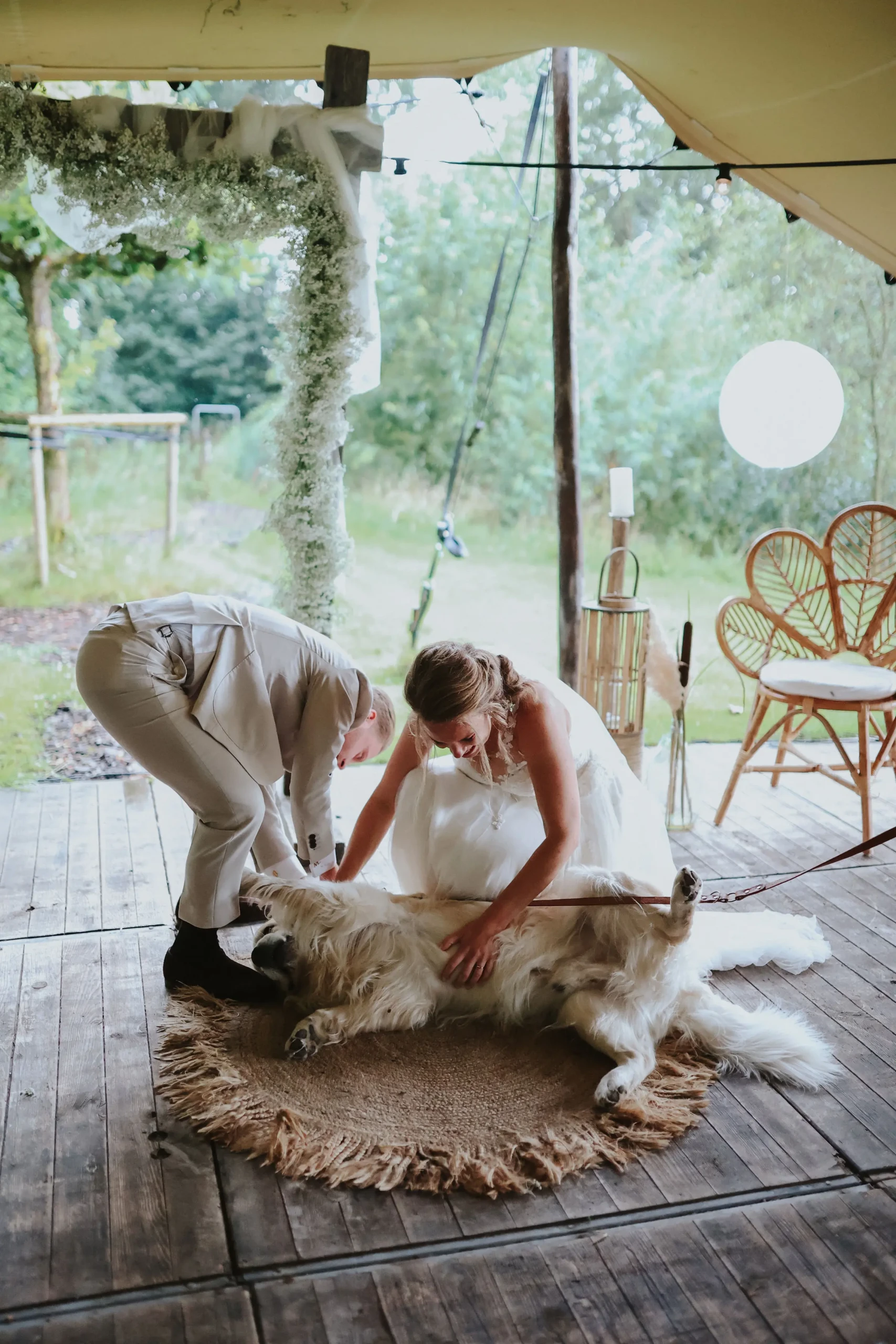 Hond met bruidspaar op bruiloft tijdens ceremonie.