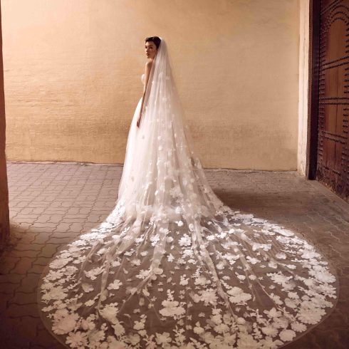 Bruid met prachtige lange sluier vol versieringen.