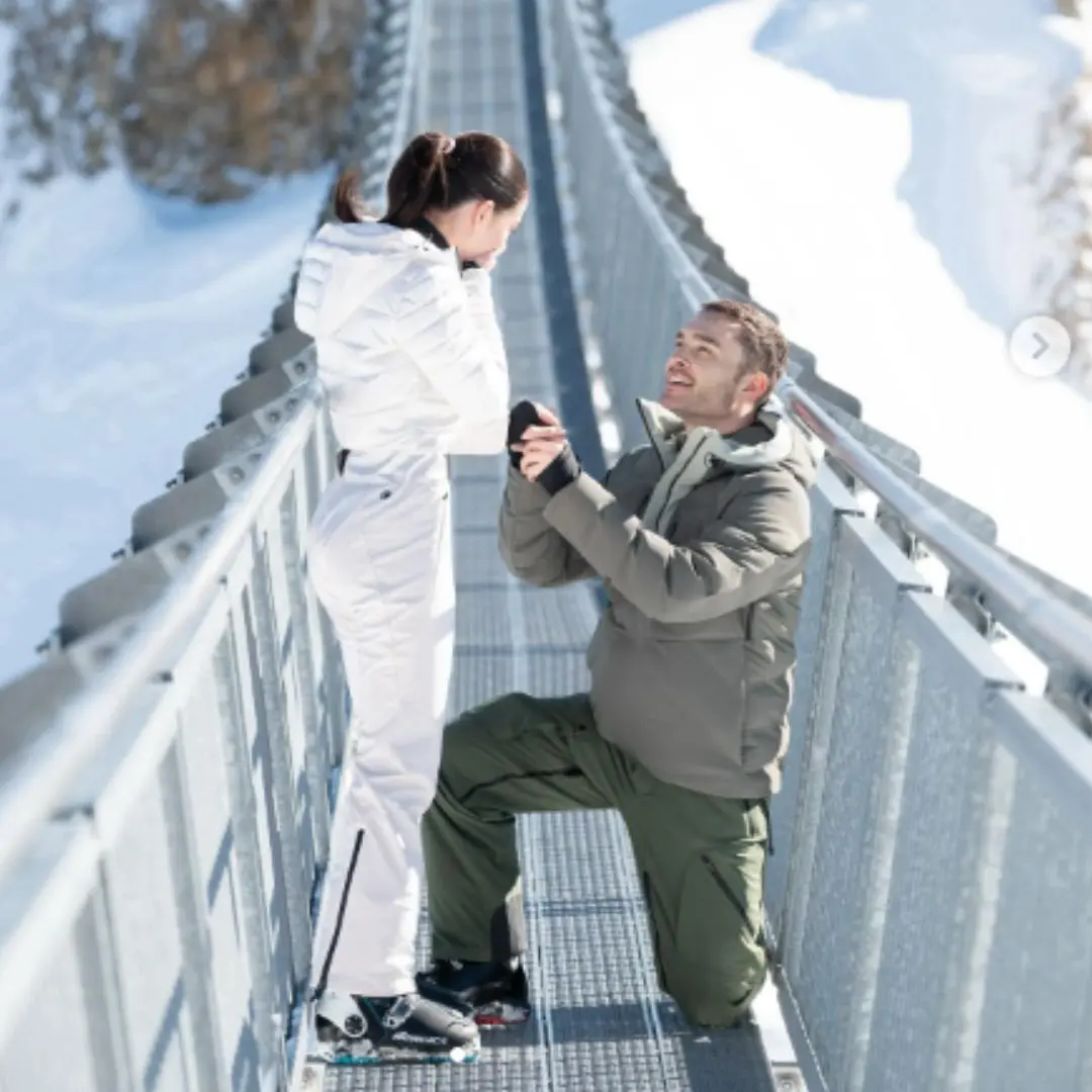 aanzoek op een hoge hangbrug tussen twee besneeuwde bergen in.