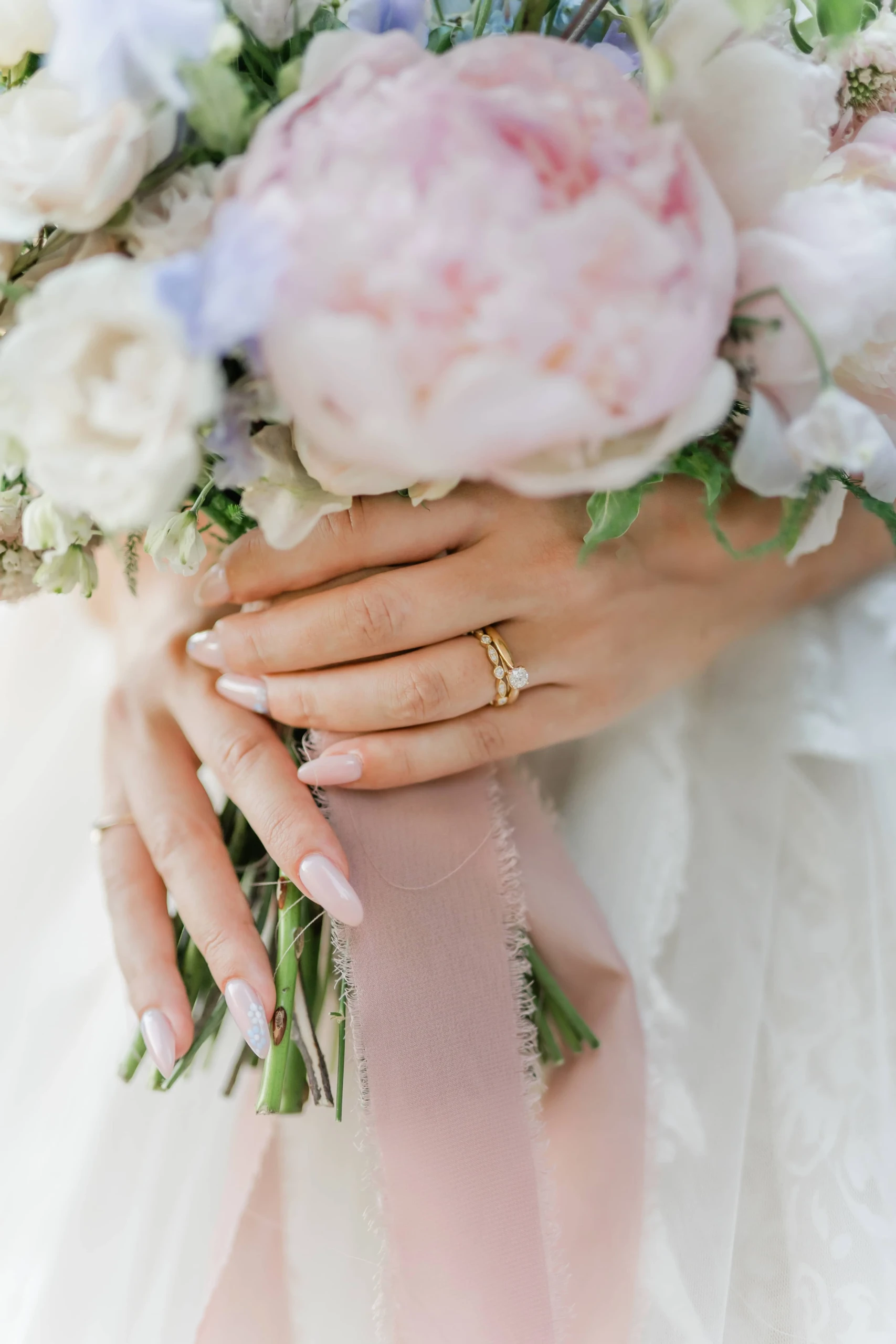 Close up op bruidsboeket met pastelkleurige bloemen en peonies.