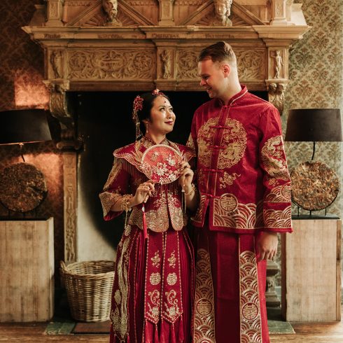 Bruidspaar in traditionele Chinese kleding staat naast elkaar.