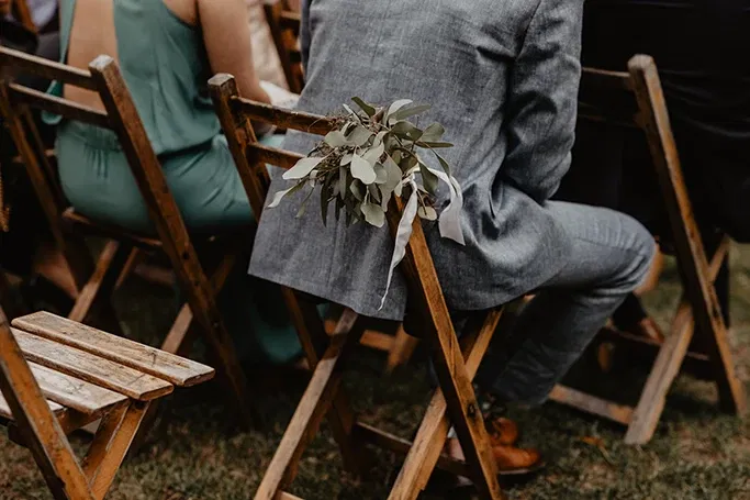 Bruiloftsgasten in houten stoelen, ceremonie opstelling