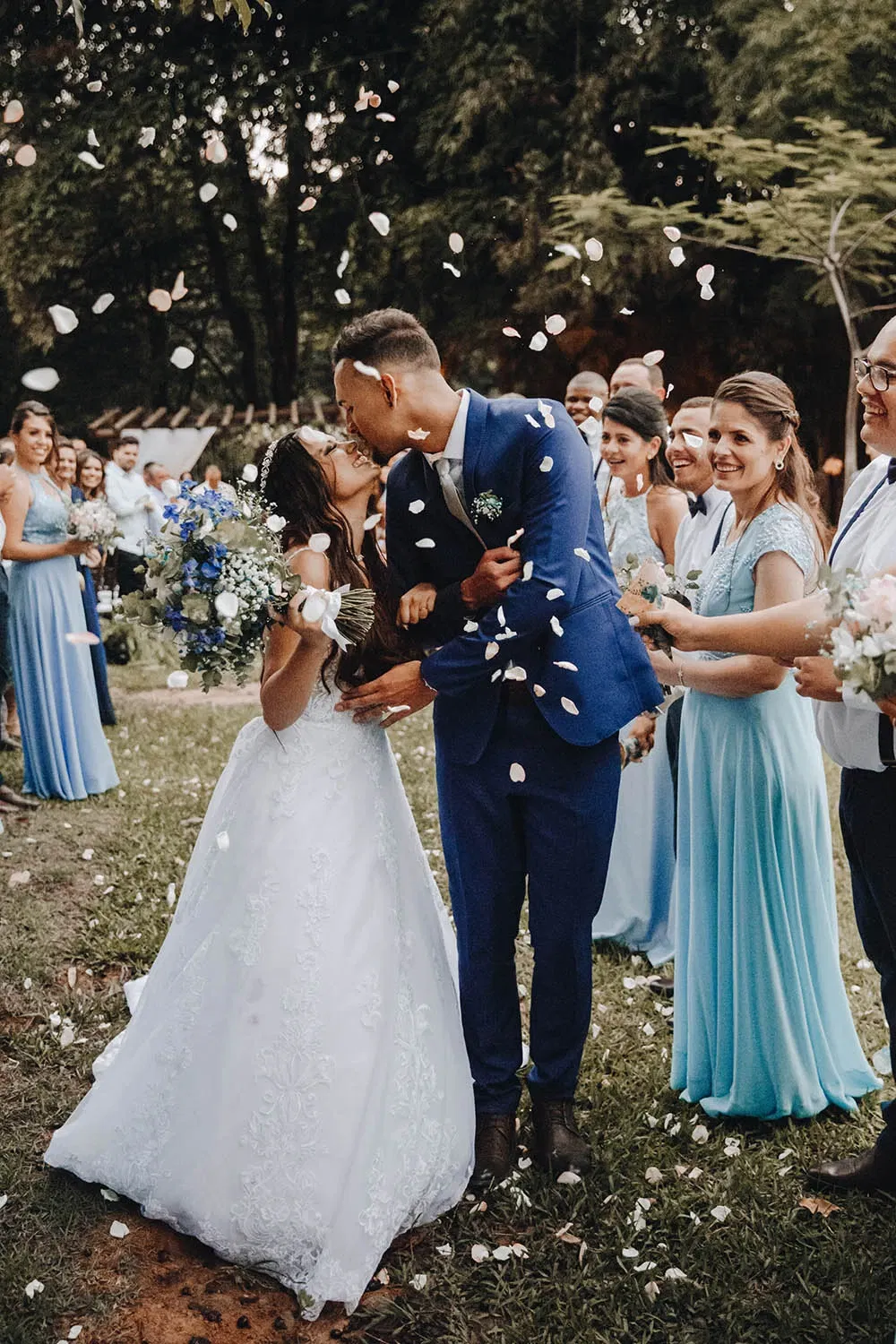 Bruidspaar kust en gasten gooien confetti.