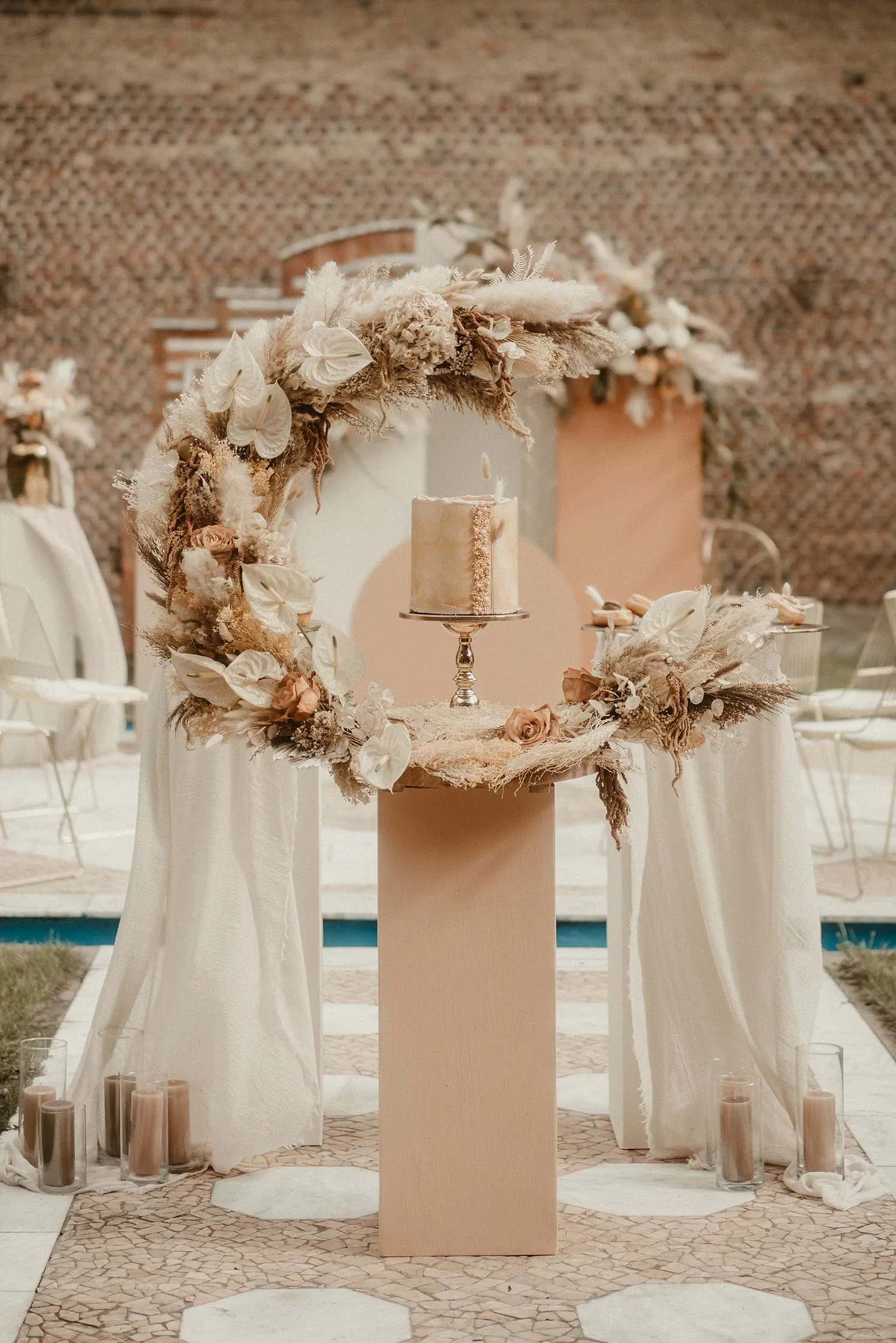 boho-bruiloft pampasgras en bloemen-boog om bruidstaart