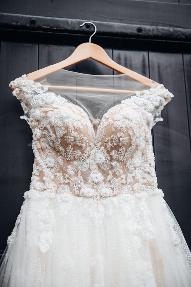 close-up van trouwjurk vol versieringen en kralen.