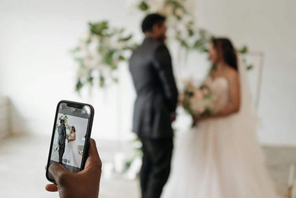 Bruiloftsgast maakt foto van bruidspaar met iphone