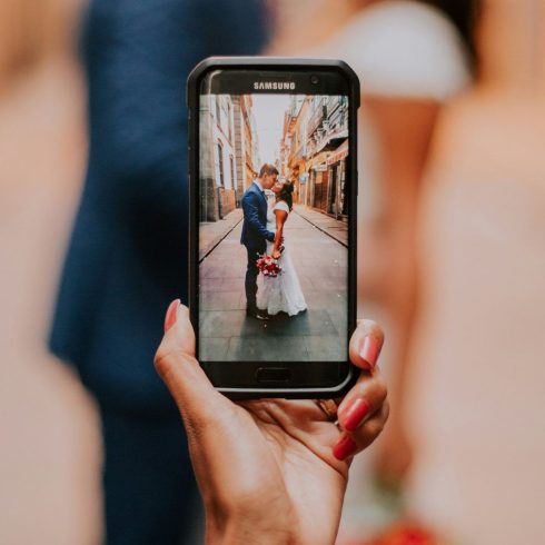 Gast maakt foto met Samsung telefoon van bruidspaar