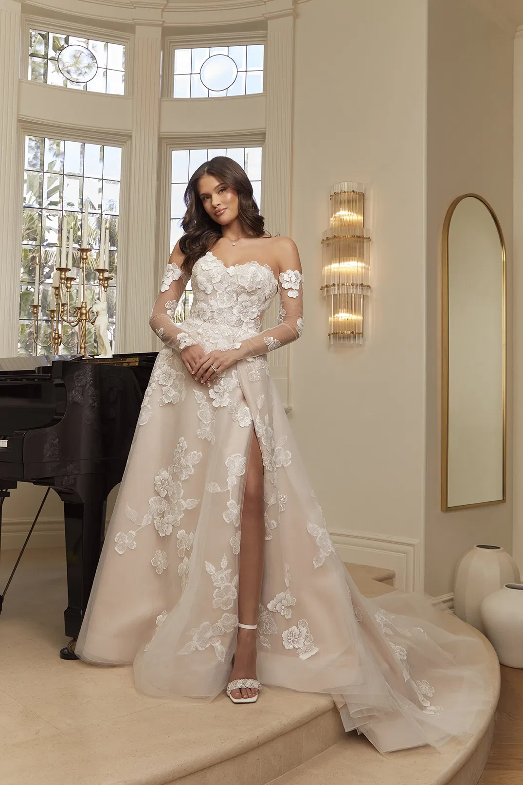 bruid in strapless trouwjurk met losse mouwtjes. prachtige bloemen versiering en a-lijn rok met split.